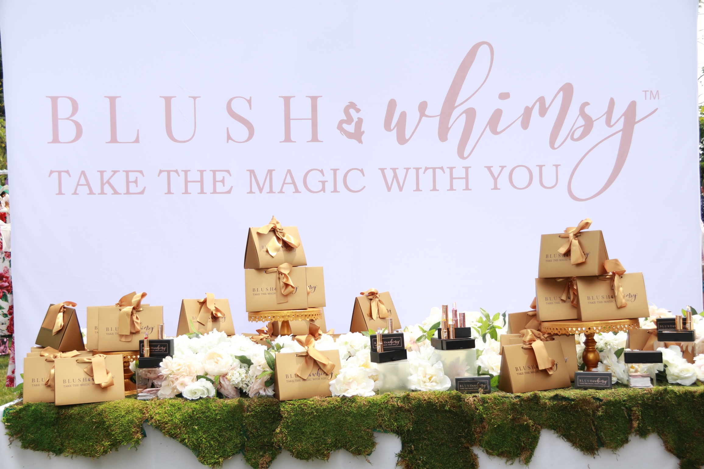 Original Blush & Whimsy event installation with flower lipsticks, rose-gold gift boxes and the Take the Magic With You brand backdrop