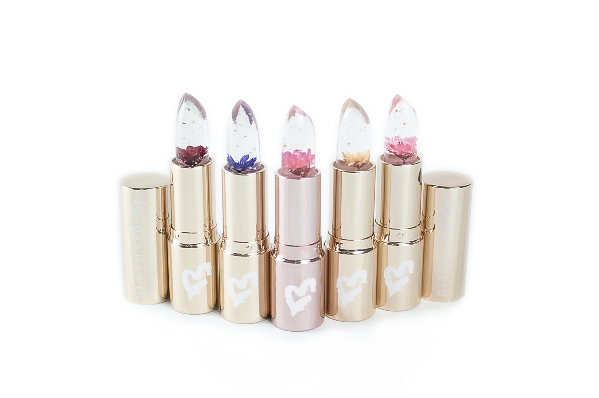 Five original Blush & Whimsy flower lipsticks with real flowers suspended in the clear formula
