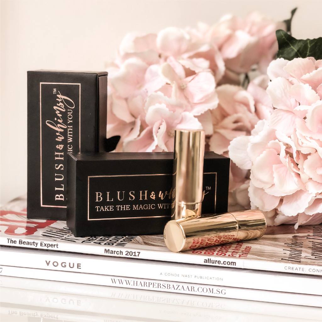 Blush & Whimsy rose-gold lipstick packaging styled with blush flowers and beauty magazines
